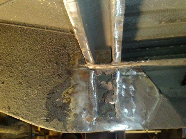 Rust hole in the frame between the cross brace and outrigger front rigth side
